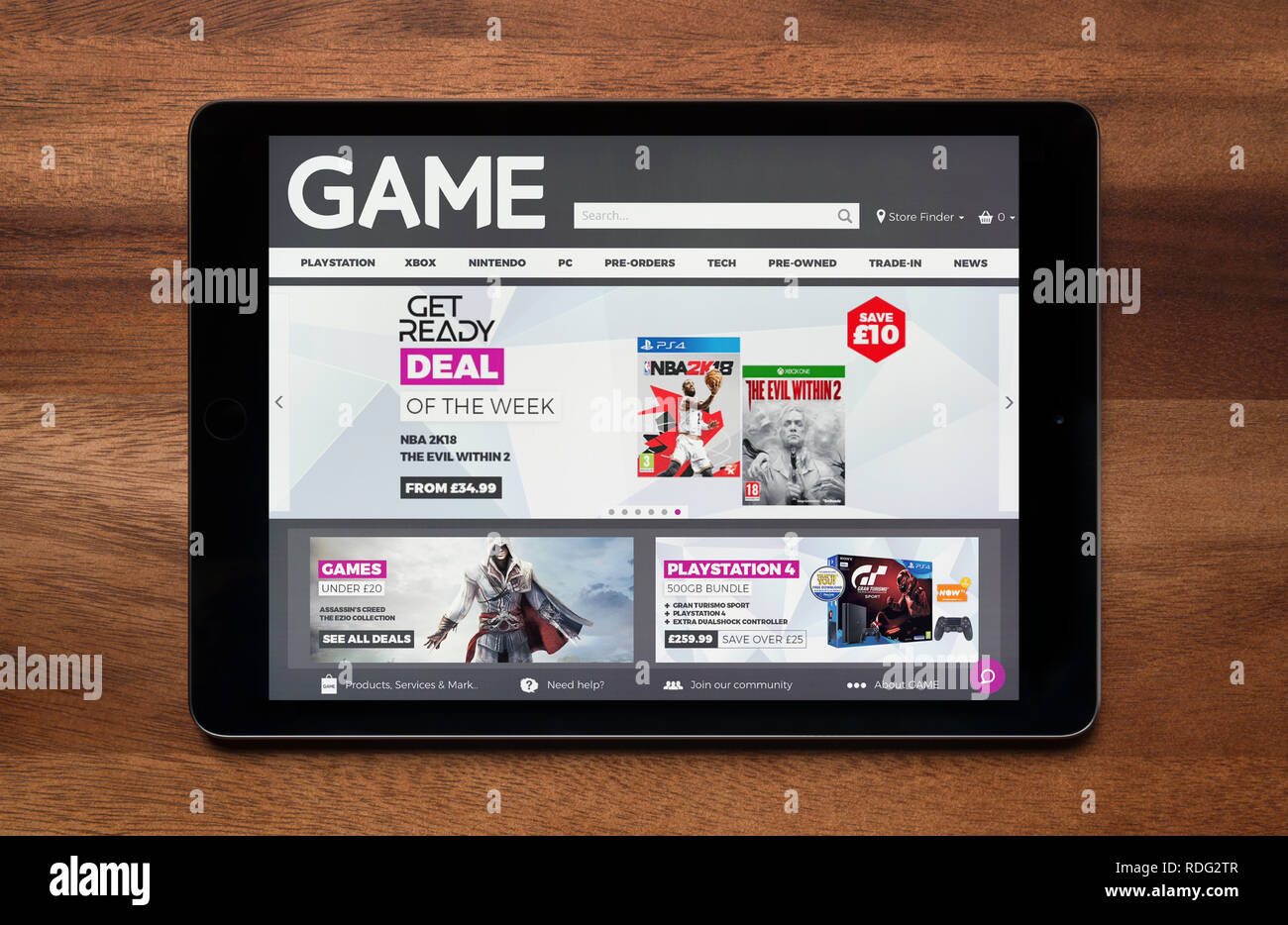 The website of Game is seen on an iPad tablet, which is resting on a wooden table (Editorial use only). Stock Photo
