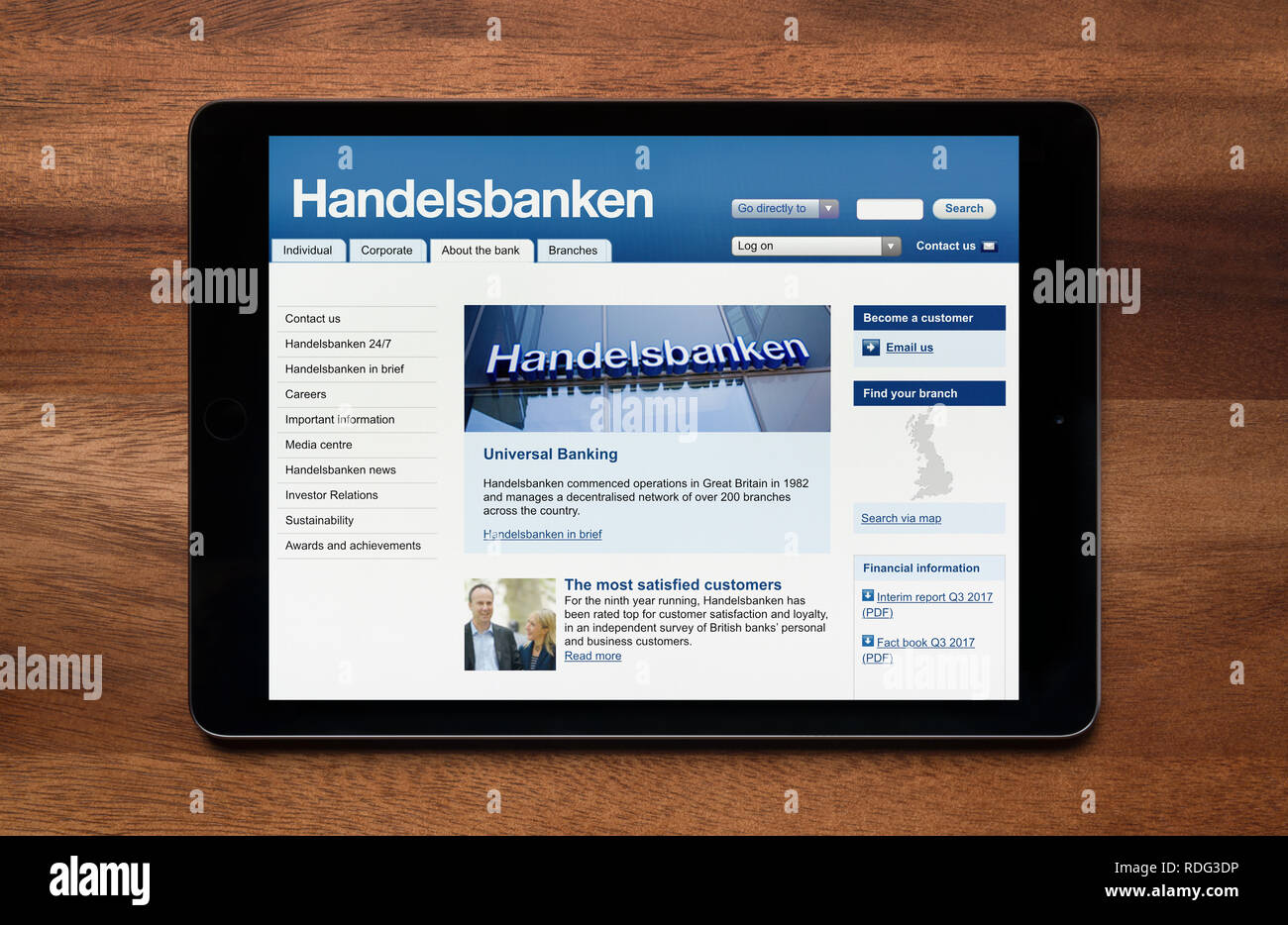 The website of Handelsbanken is seen on an iPad tablet, which is resting on a wooden table (Editorial use only). Stock Photo