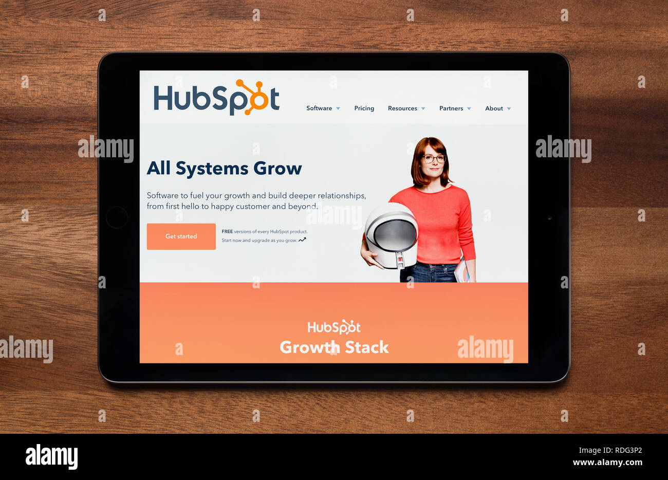 The website of HubSpot is seen on an iPad tablet, which is resting on a wooden table (Editorial use only). Stock Photo