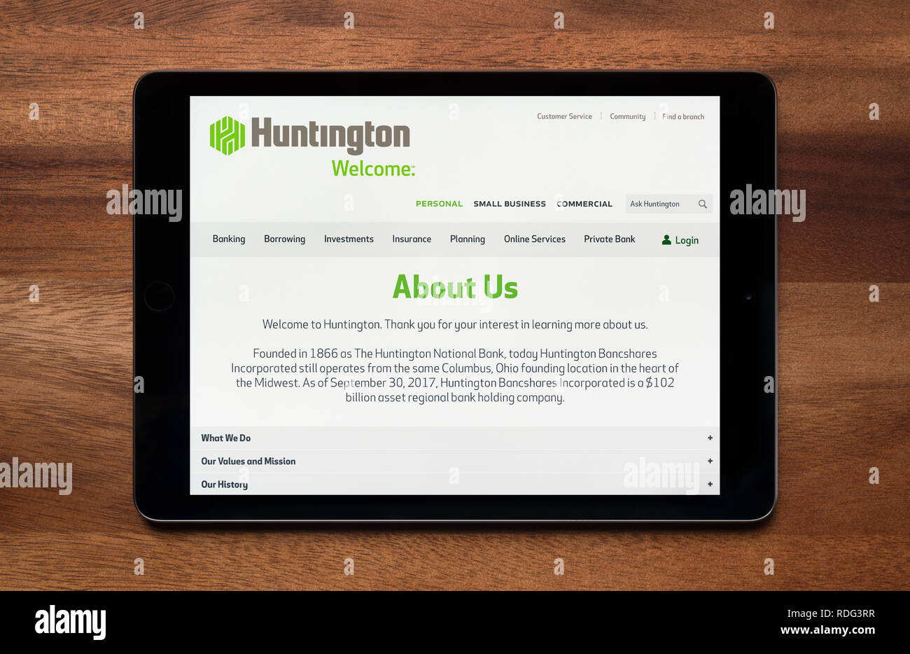 The website of Huntington Bancshares is seen on an iPad tablet, which is resting on a wooden table (Editorial use only). Stock Photo