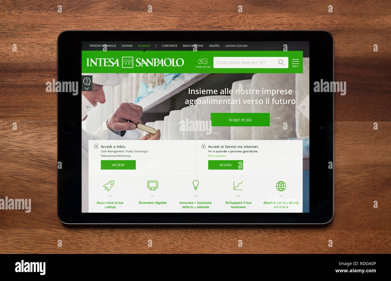 The website of Intesa Sanpaolo bank is seen on an iPad tablet, which is  resting on a wooden table (Editorial use only Stock Photo - Alamy