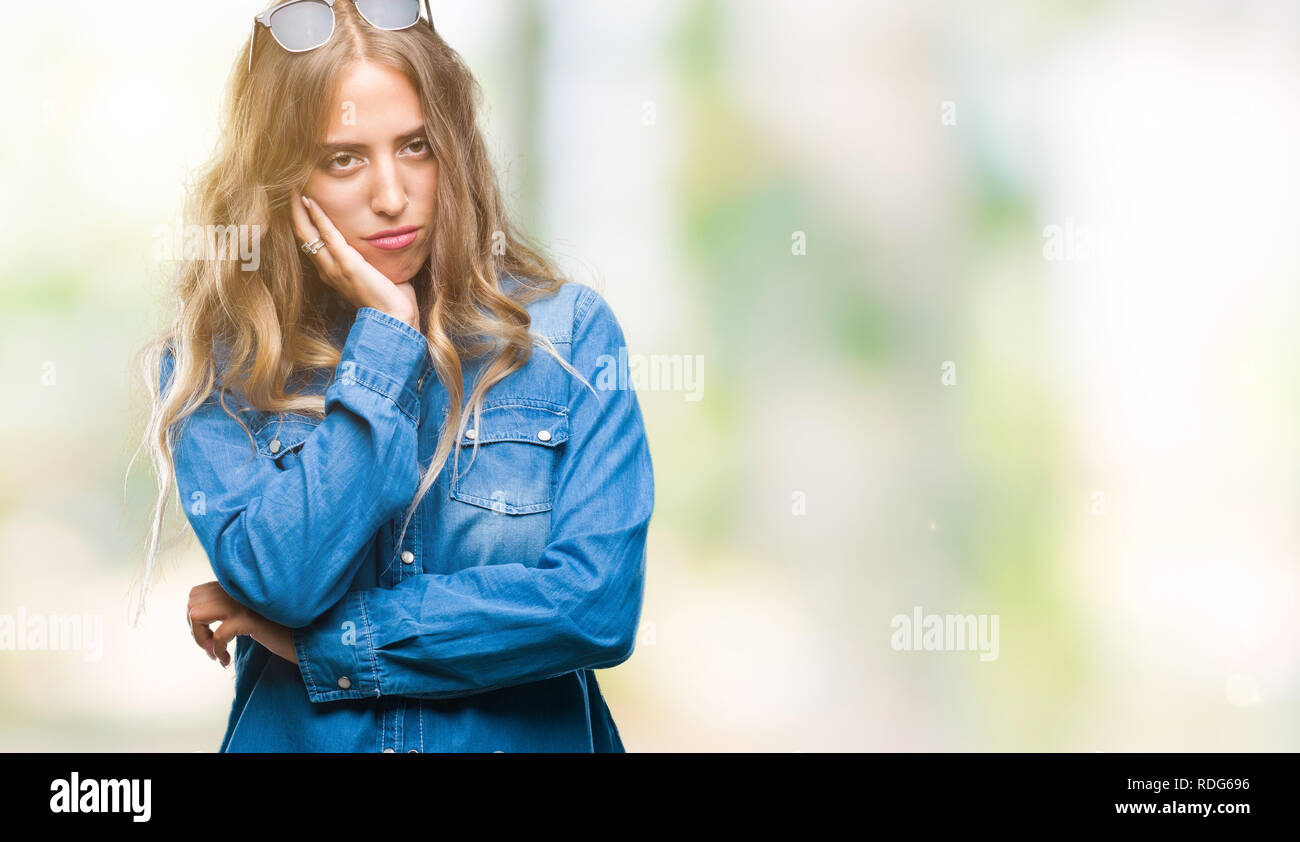 Beautiful young blonde woman wearing sunglasses over isolated