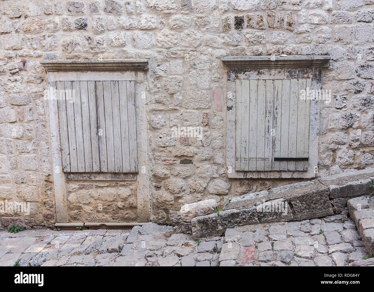 Old windows closed with wooden shutters in the stone wall Stock Photo ...