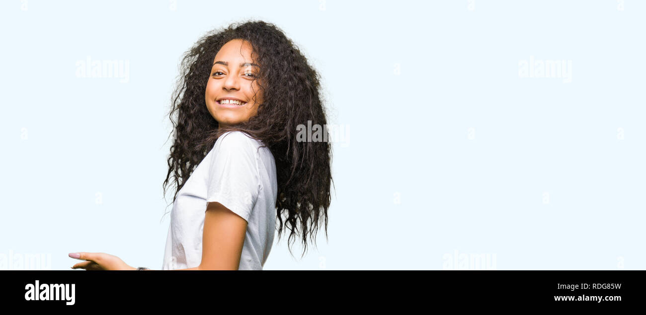 Young Beautiful Girl With Curly Hair Wearing Casual White T Shirt