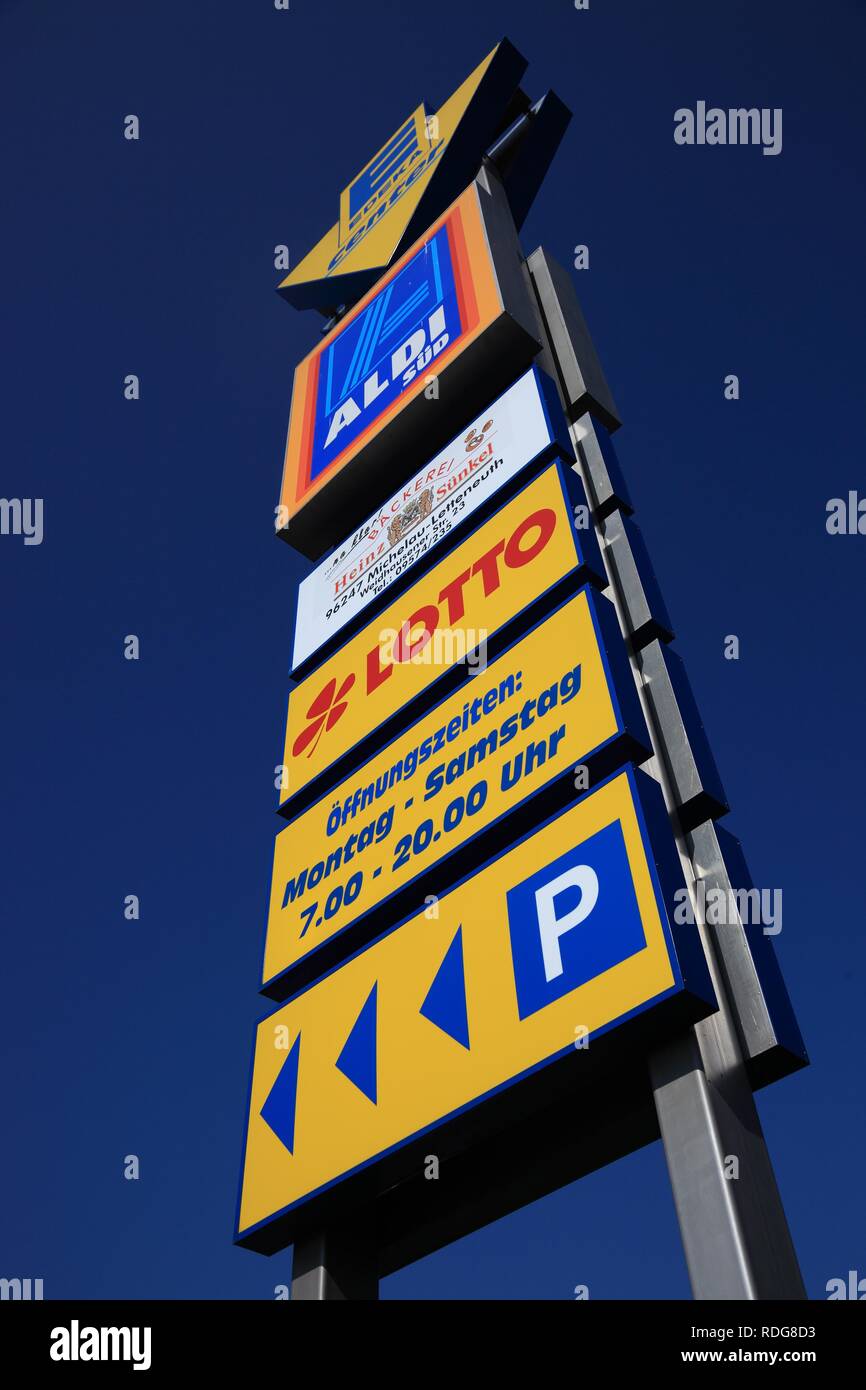 Advertising sign with opening times and car park for Edeka and Aldi supermarkets Stock Photo