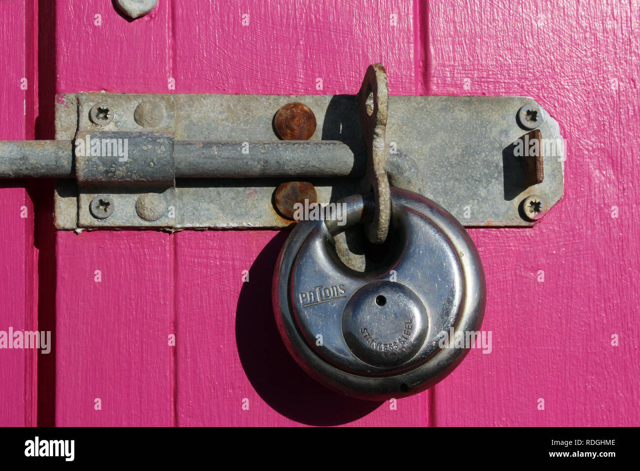 Fuchsia wooden hut door padlock close-up, Brighton, England Stock Photo