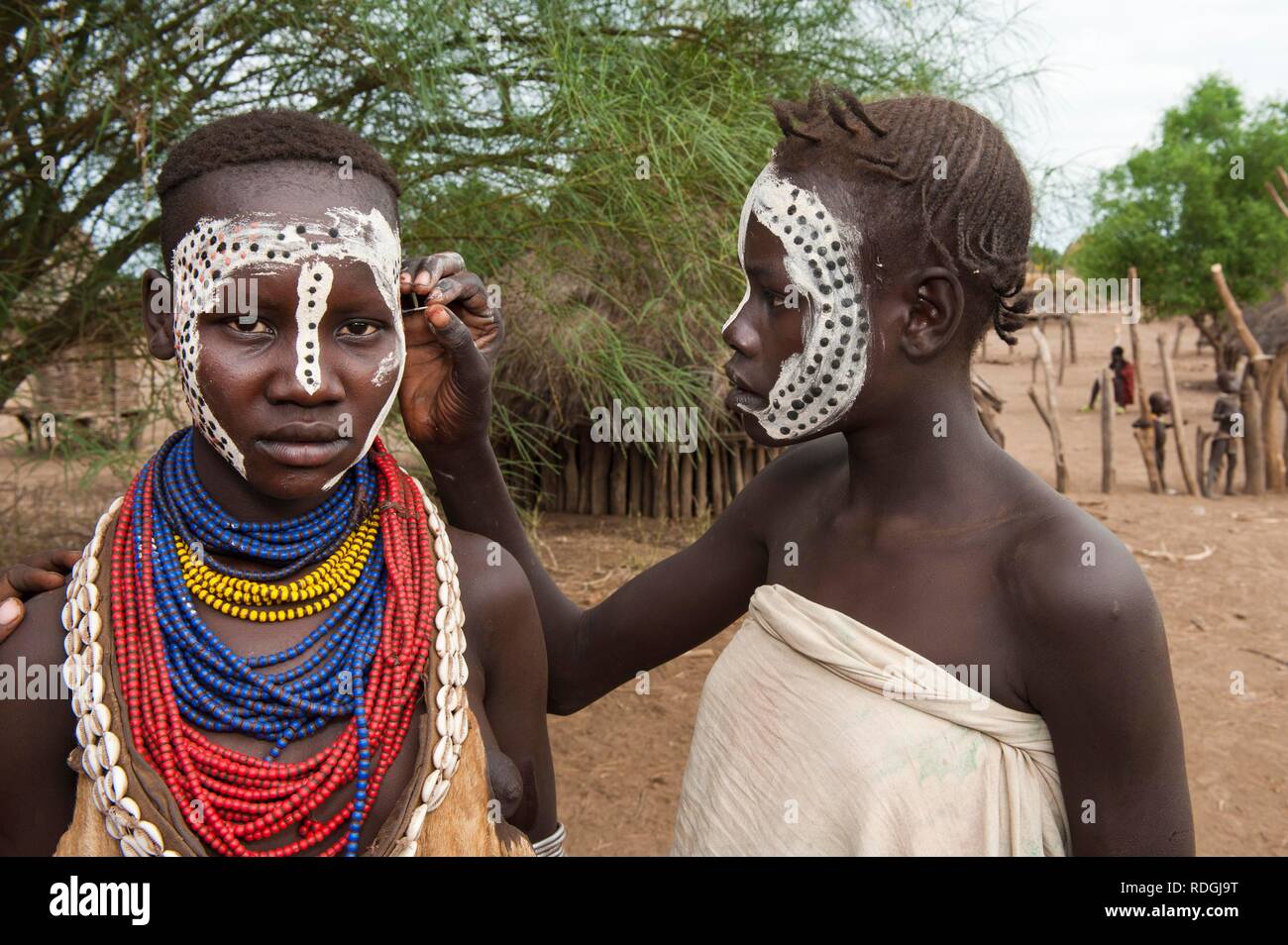 Young Karo woman getting make-up, facial paintings, Omo river valley, Southern Ethiopia, Africa Stock Photo