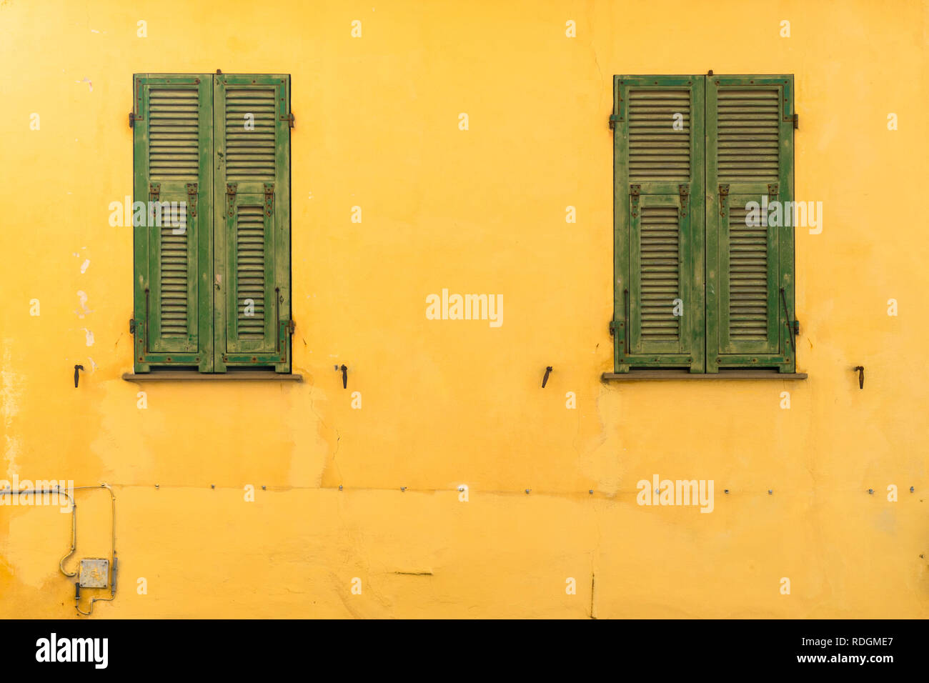 grüne geschlossene Fenster an gelber Fassade, Cervo, Riviera di Ponente, Liguria, Italy Stock Photo