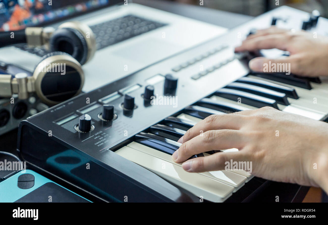 Musician is recording Keyboard on to Computer Music Studio Stock Photo