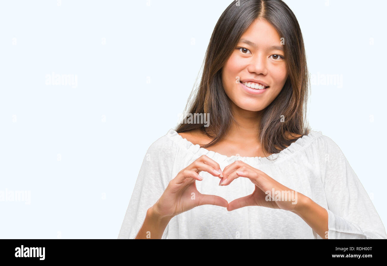 Young asian woman over isolated background smiling in love showing ...
