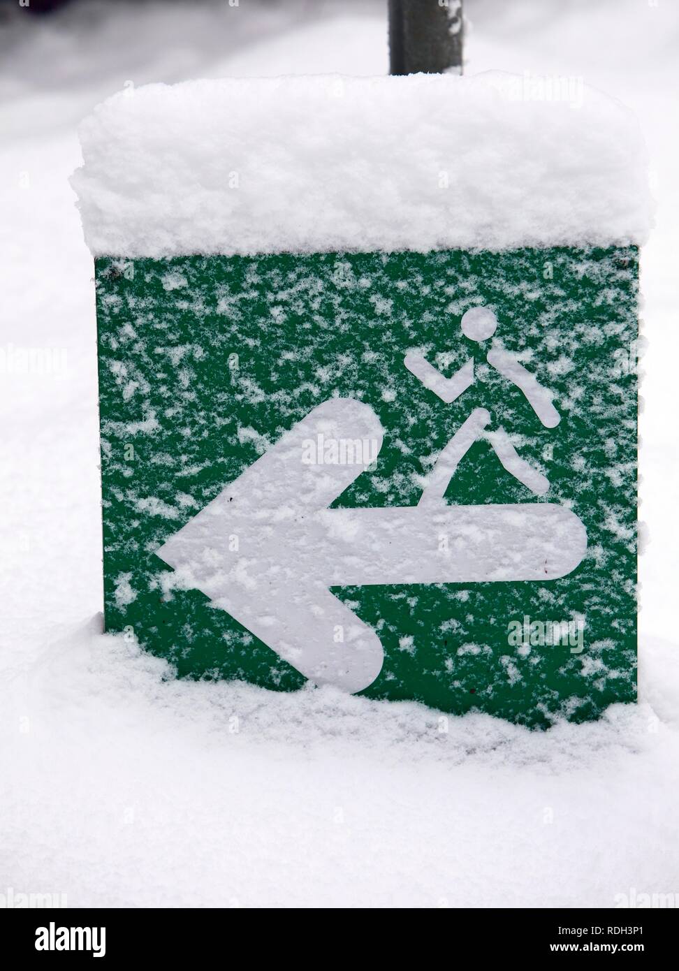 Snow-covered sign on a jogging path in Gruga Park, Essen, North Rhine-Westphalia Stock Photo