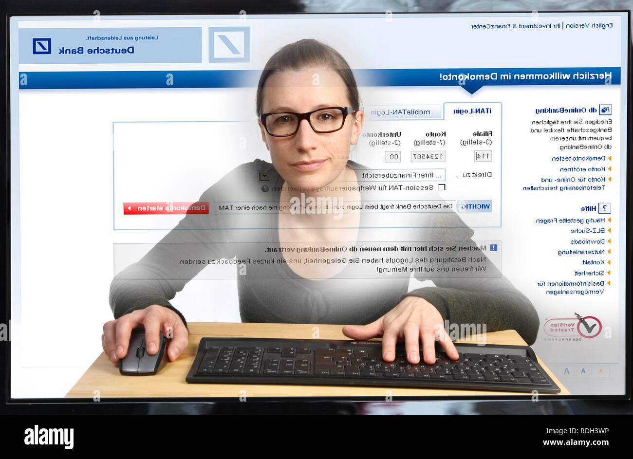 Young woman sitting at a computer surfing the Internet, viewing an Internet banking page, Deutsche Bank Stock Photo