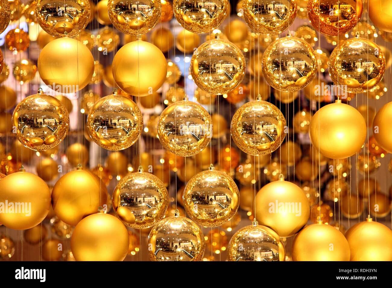 Christmas decorations, many small golden Christmas baubles make up one large Christmas bauble hanging in the staircase of a Stock Photo