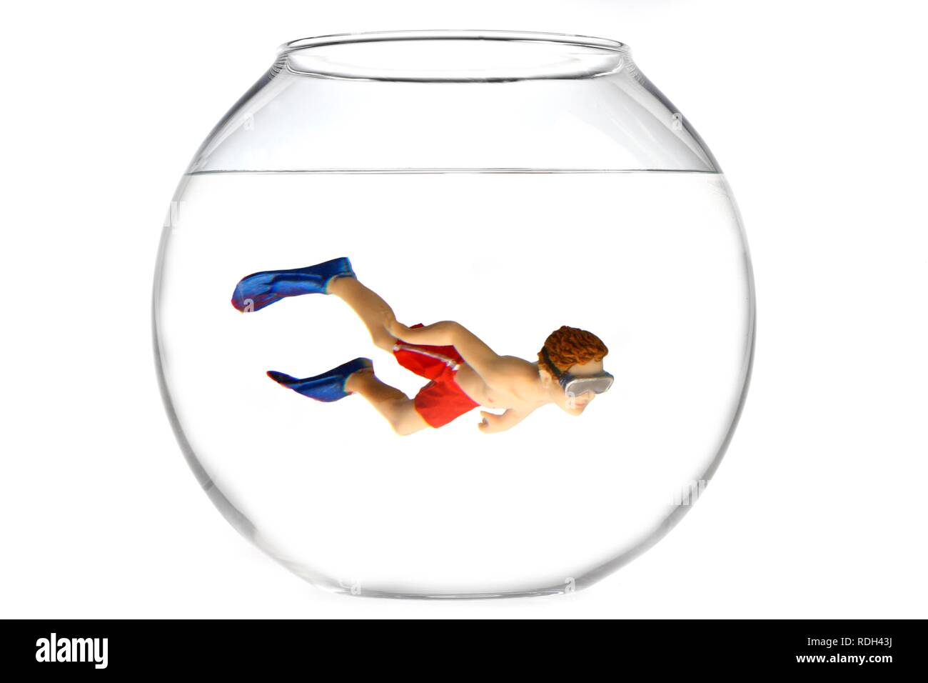 Toy boy swimming with diving goggles and flippers in a fish bowl, illustration Stock Photo