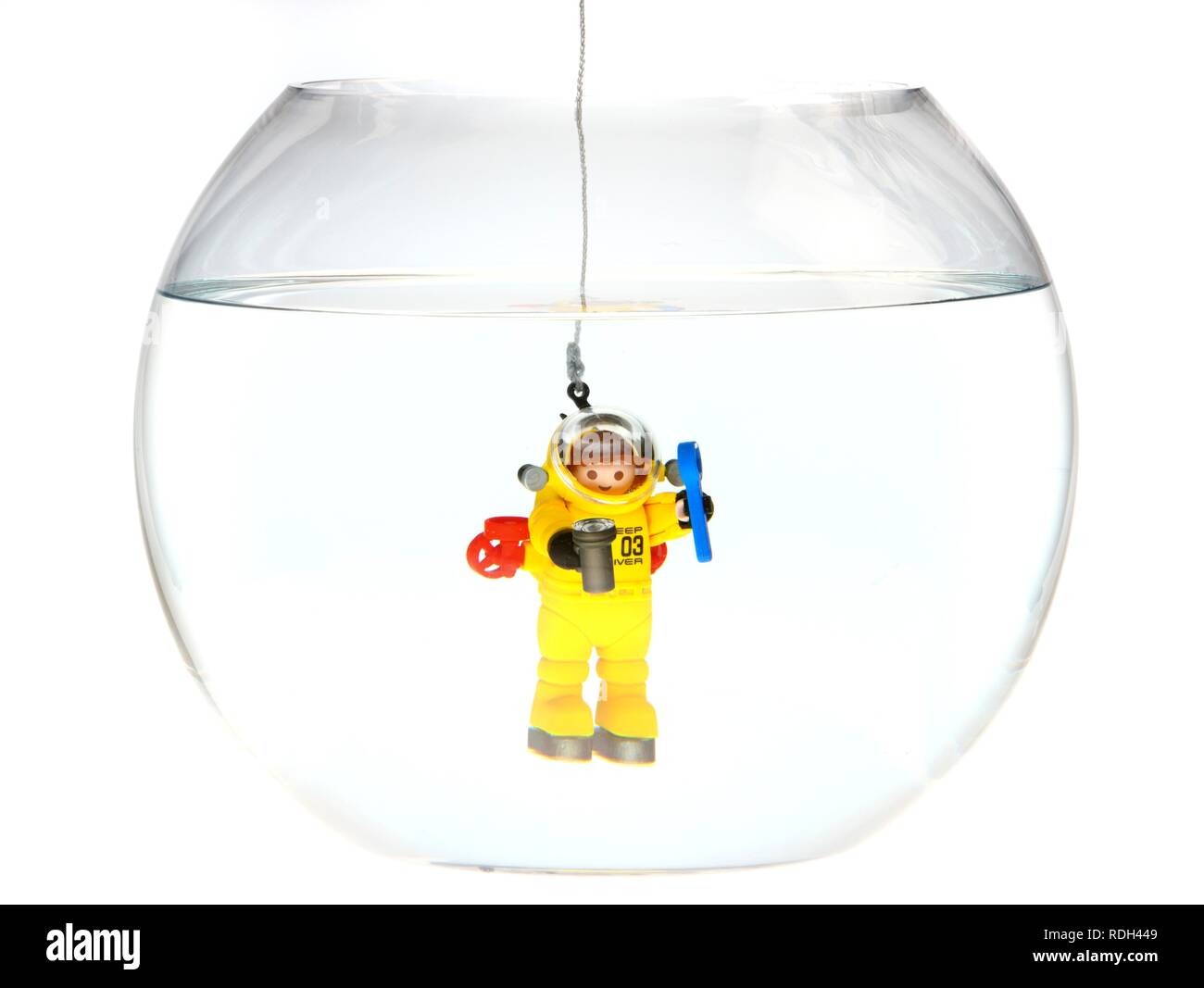 Toy deep sea diver diving in a fish bowl, illustration Stock Photo