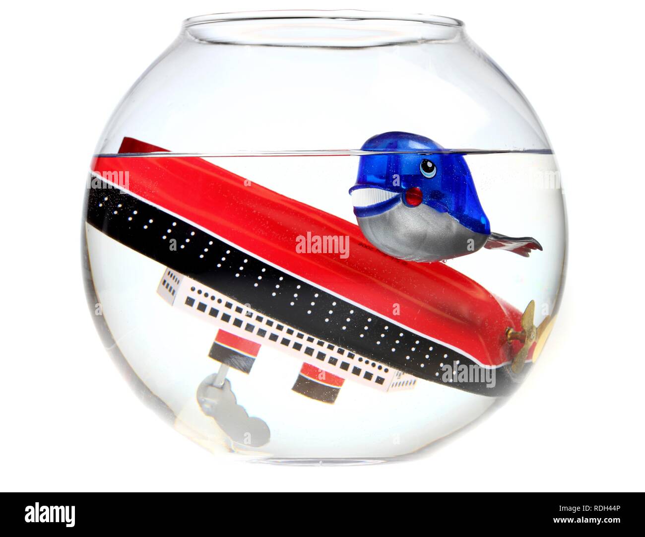 Wind-up toy whale and a sunken toy cruise ship in a fish bowl, illustration Stock Photo