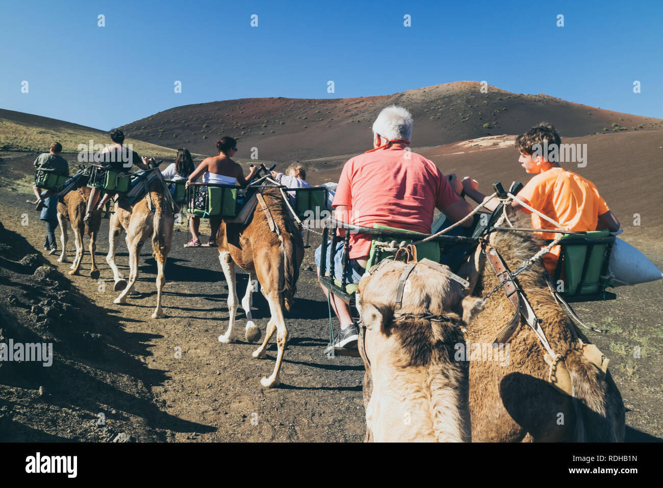 Tourists taking a camel ride at Lanzarote Timanfaya National Park  (Parque Nacional de Timanfaya) Lanzarote, Las palmas, Canary Islands, Spain, Europe Stock Photo