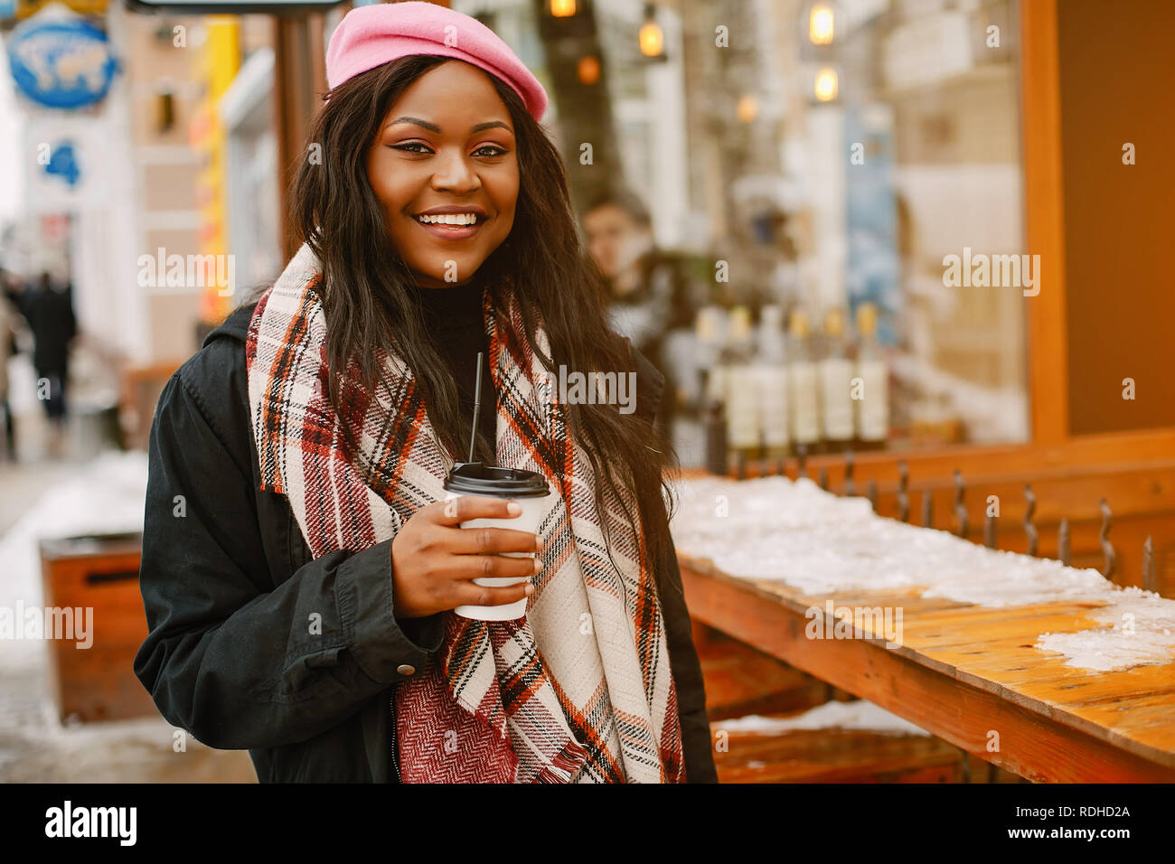 Cute black woman have fun in a city. Beautiful black girl in a pink ...
