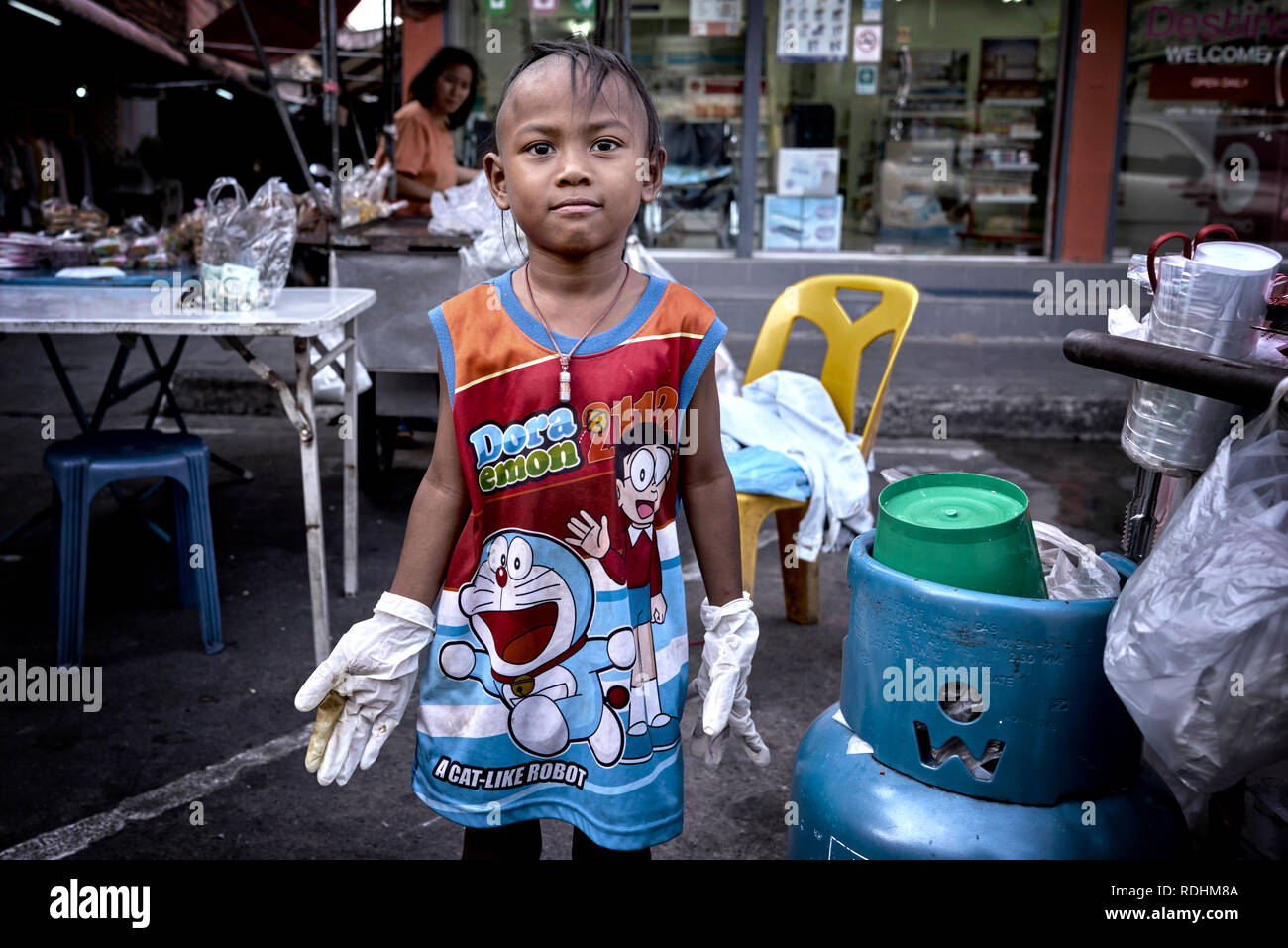 Thailand child helping at the family street food stall. funny kids Stock Photo