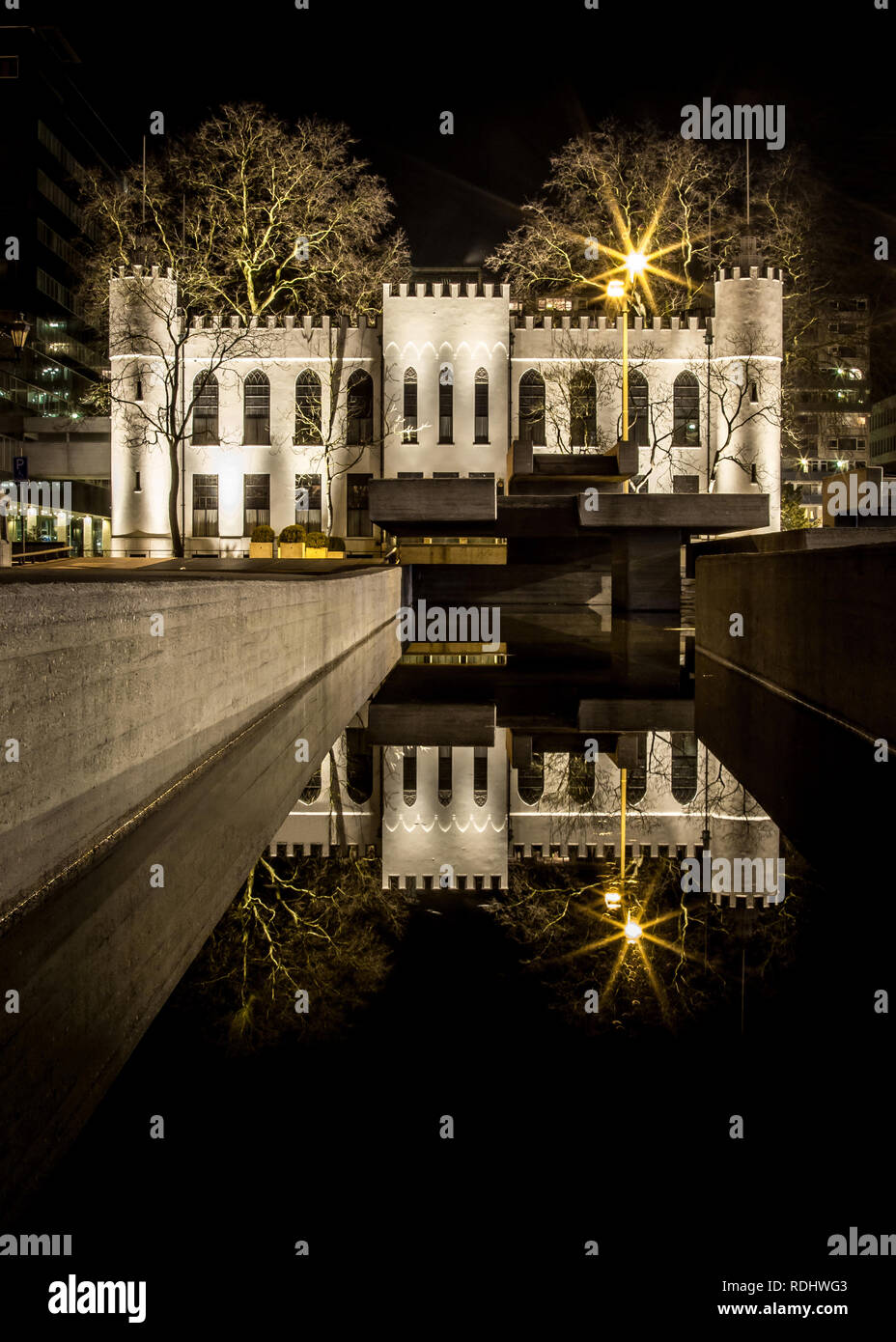 Mystic city hall of Tilburg at night with reflection in the water