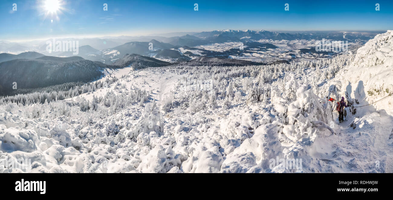 Hiking in idyllic snowy mountains of Slovakia on sunny winter day. Stock Photo