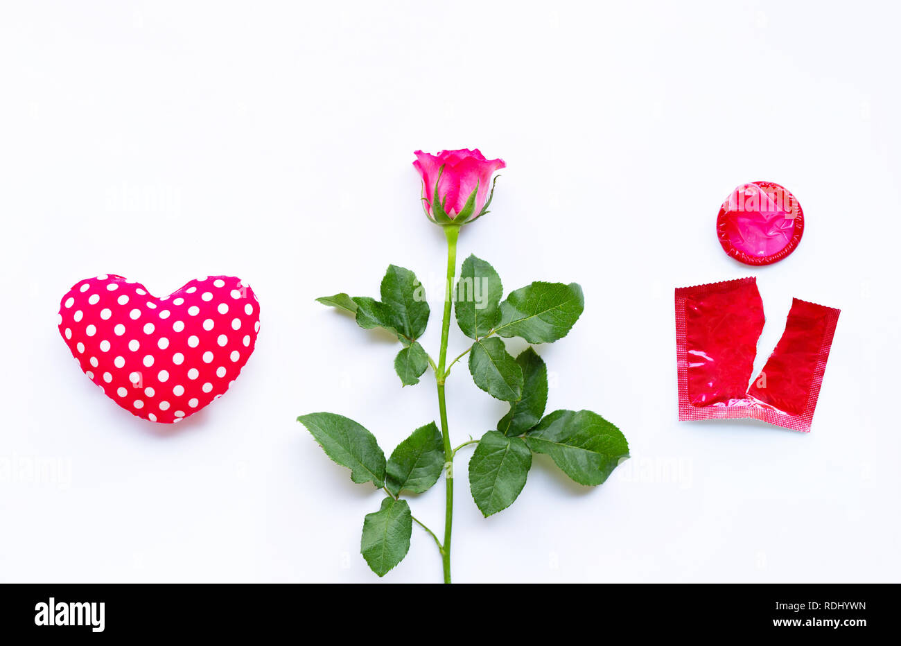 Valentines day concept, Heart with rose and red condom on white background. Stock Photo