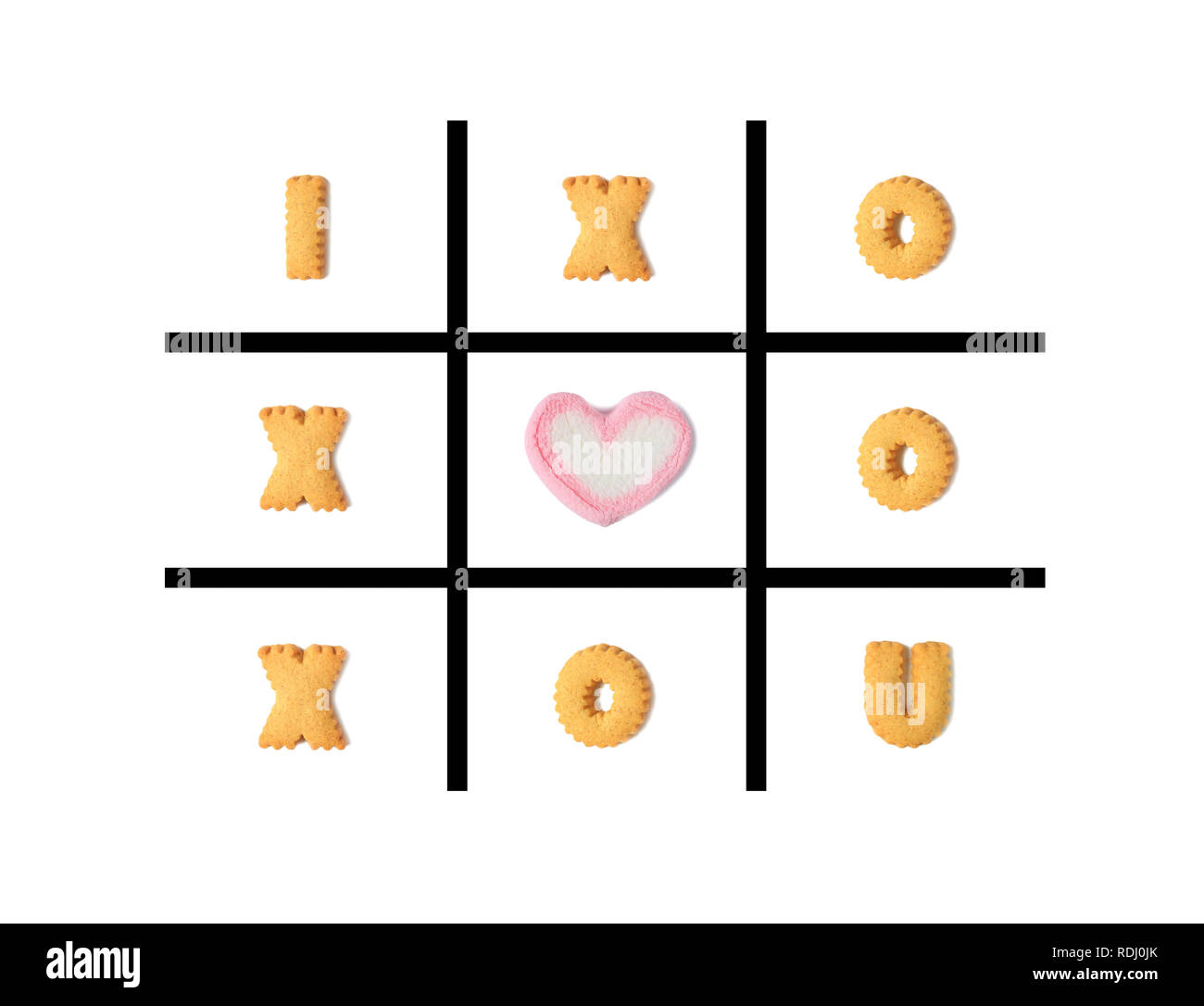 The word I LOVE U in Tic Tac Toe Game made with alphabet shaped cookies and a heart shaped marshmallow candy on white background Stock Photo