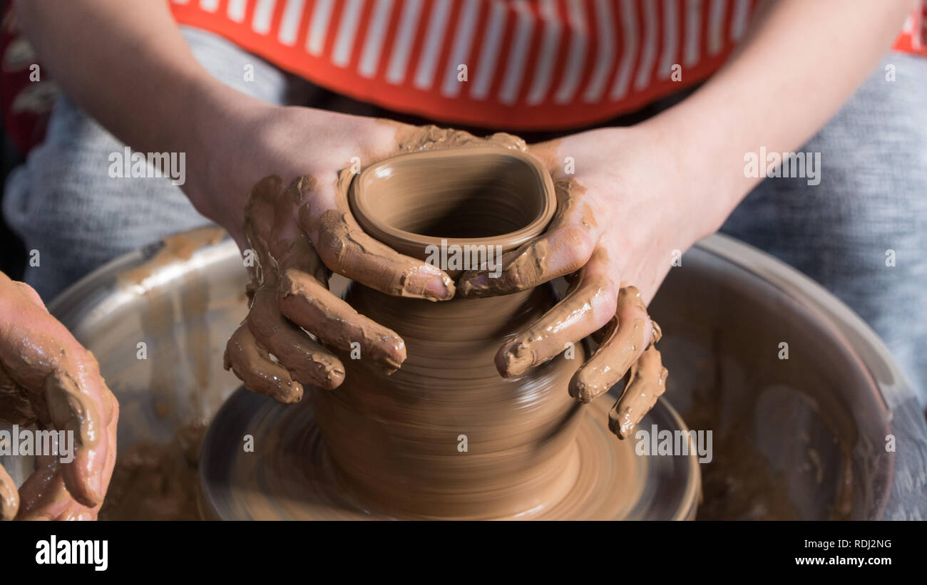 Teaching pottery to children. The teacher gives a master class in modeling Stock Photo