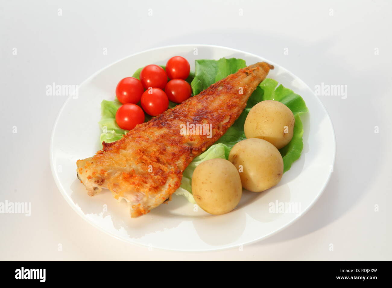 Fish for dinner with potatoes and vegetables Stock Photo - Alamy