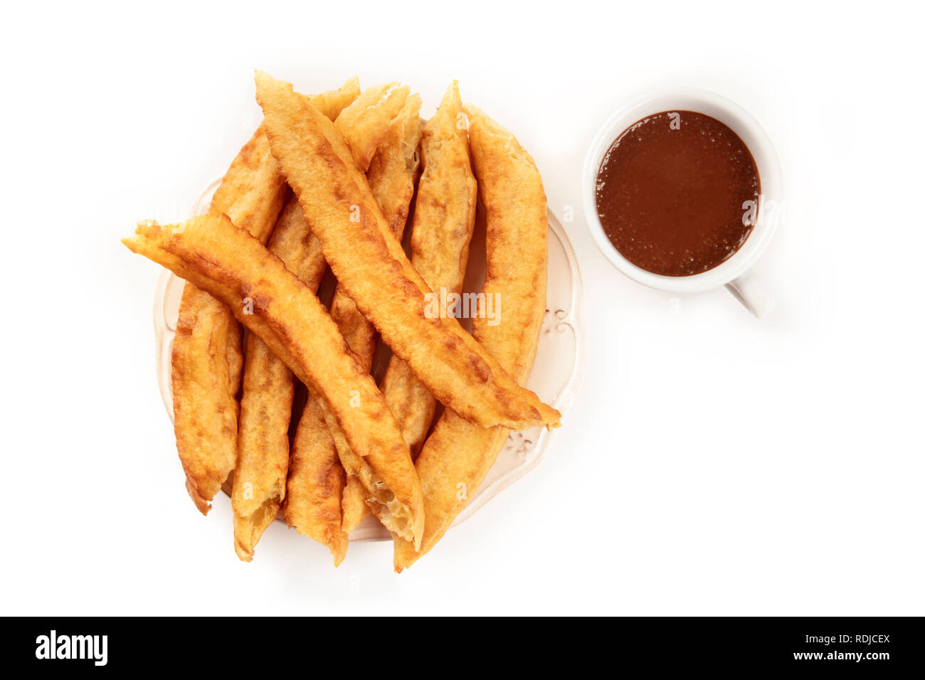 Traditional Spanish porras with hot chocolate, a typical Madrid Sunday breakfast, shot from the top on a white background with a place for text Stock Photo