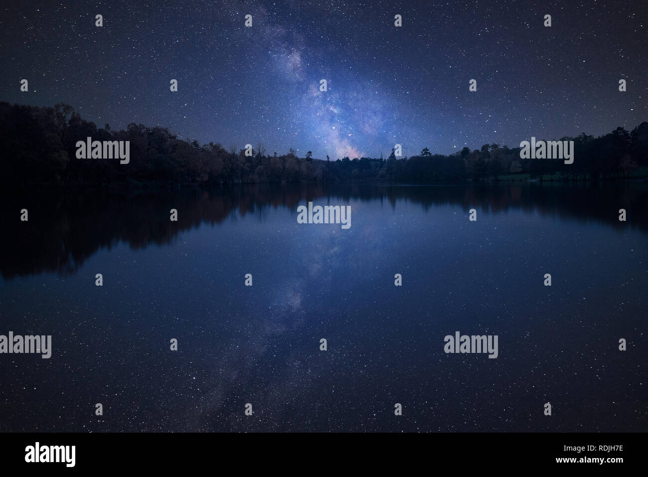 Stunning vibrant Milky Way composite image over landscape of still lake ...