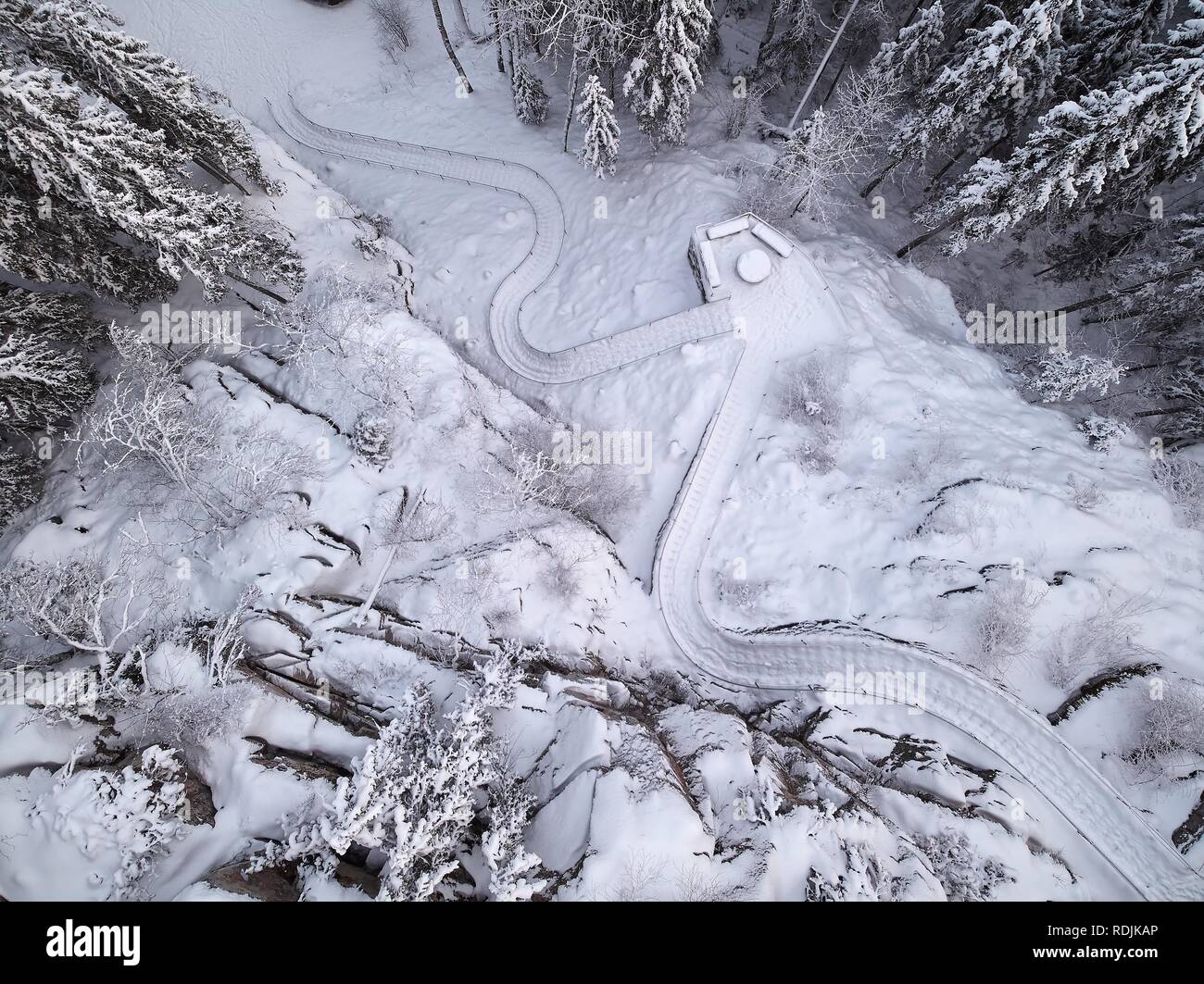 Icy outdoor stairway in Aulanko nature park in Hämeenlinna, Finland. Frozen trees in snowy landscape. Top down drone view. Stock Photo