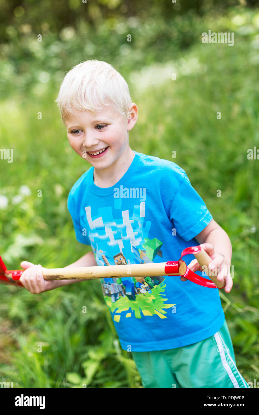 Boy with shovel standing in garden Stock Photo - Alamy