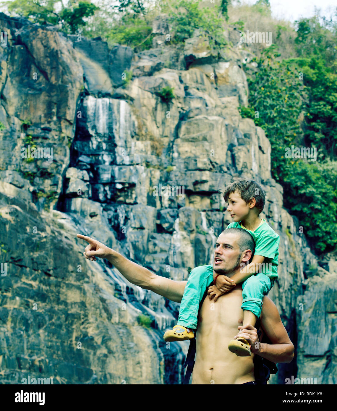 father and son making a trip to waterfall together, happy family on ...