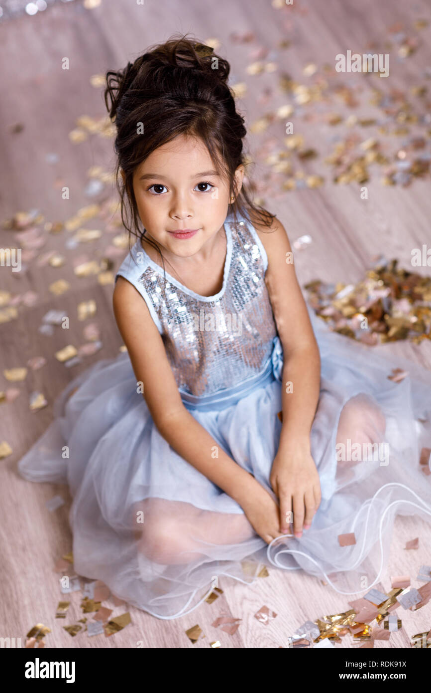 little girl in blue dress sitting on the floor with confetti Stock ...