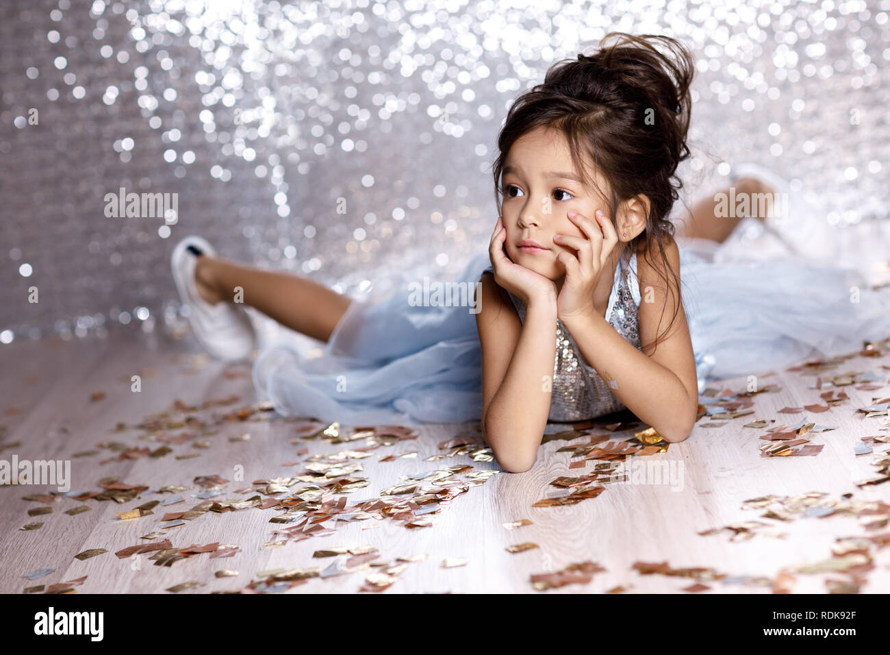 little girl in blue dress sitting on the floor with confetti Stock ...