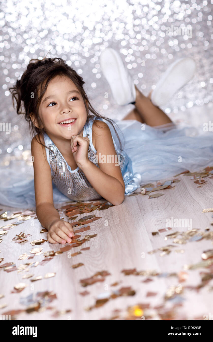 little girl in blue dress sitting on the floor with confetti Stock ...