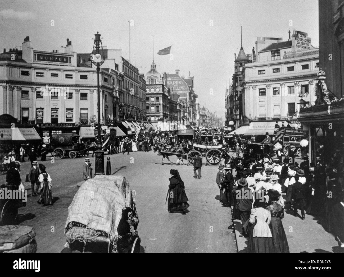 Late Victorian London. View down Oxford Street with the famous Waring and Gillow furniture makers store in the distance. The streets are full of people and horse drawn carriages. Stock Photo