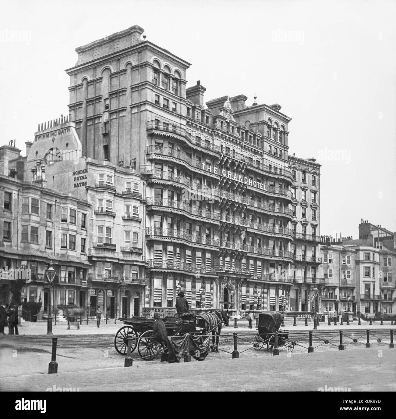 Late Victorian photograph showing The Grand Hotel in Brighton England, with the Hobden Royal Baths next to it. Men in horse drawn carriages waiting outside. Stock Photo