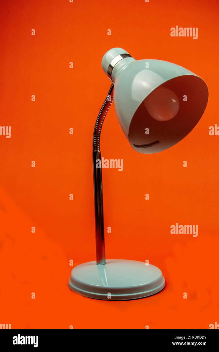 Orange Background with Blue Lamp modelled infront Stock Photo