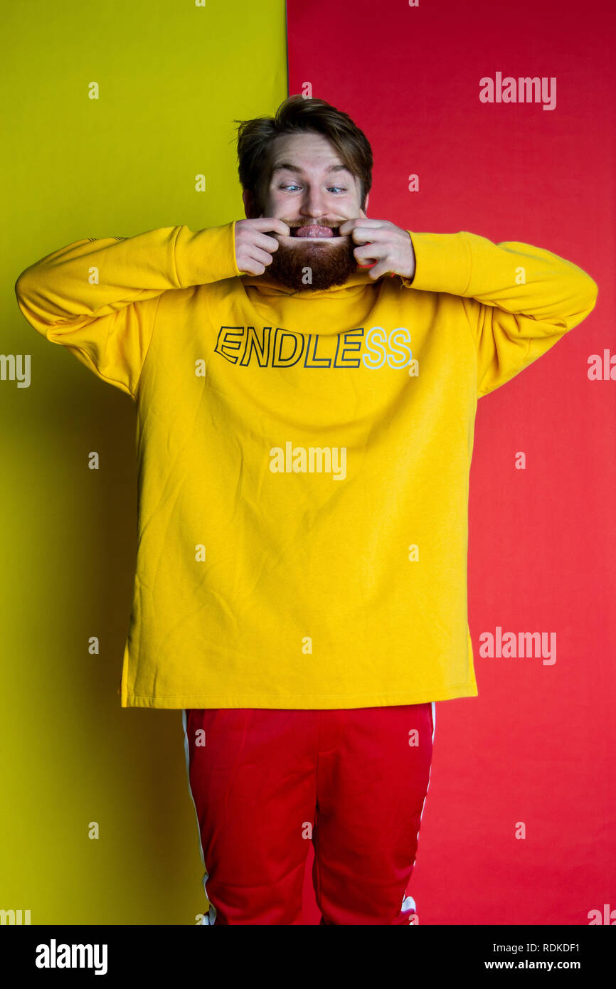 Fashion shot of male posing into the camera wearing clothes that match his backdrop Stock Photo