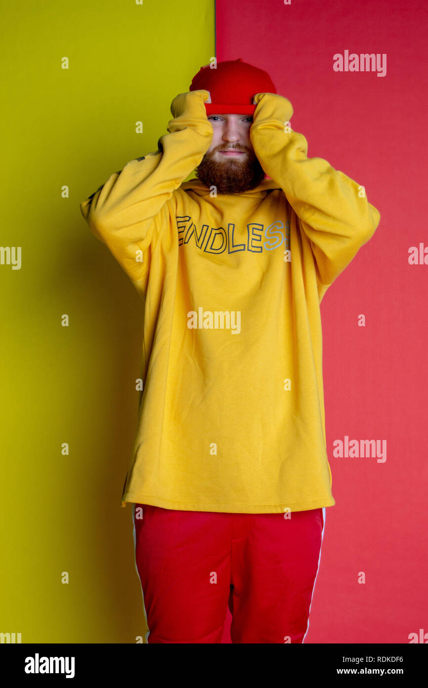 Fashion shot of male posing into the camera wearing clothes that match his backdrop Stock Photo