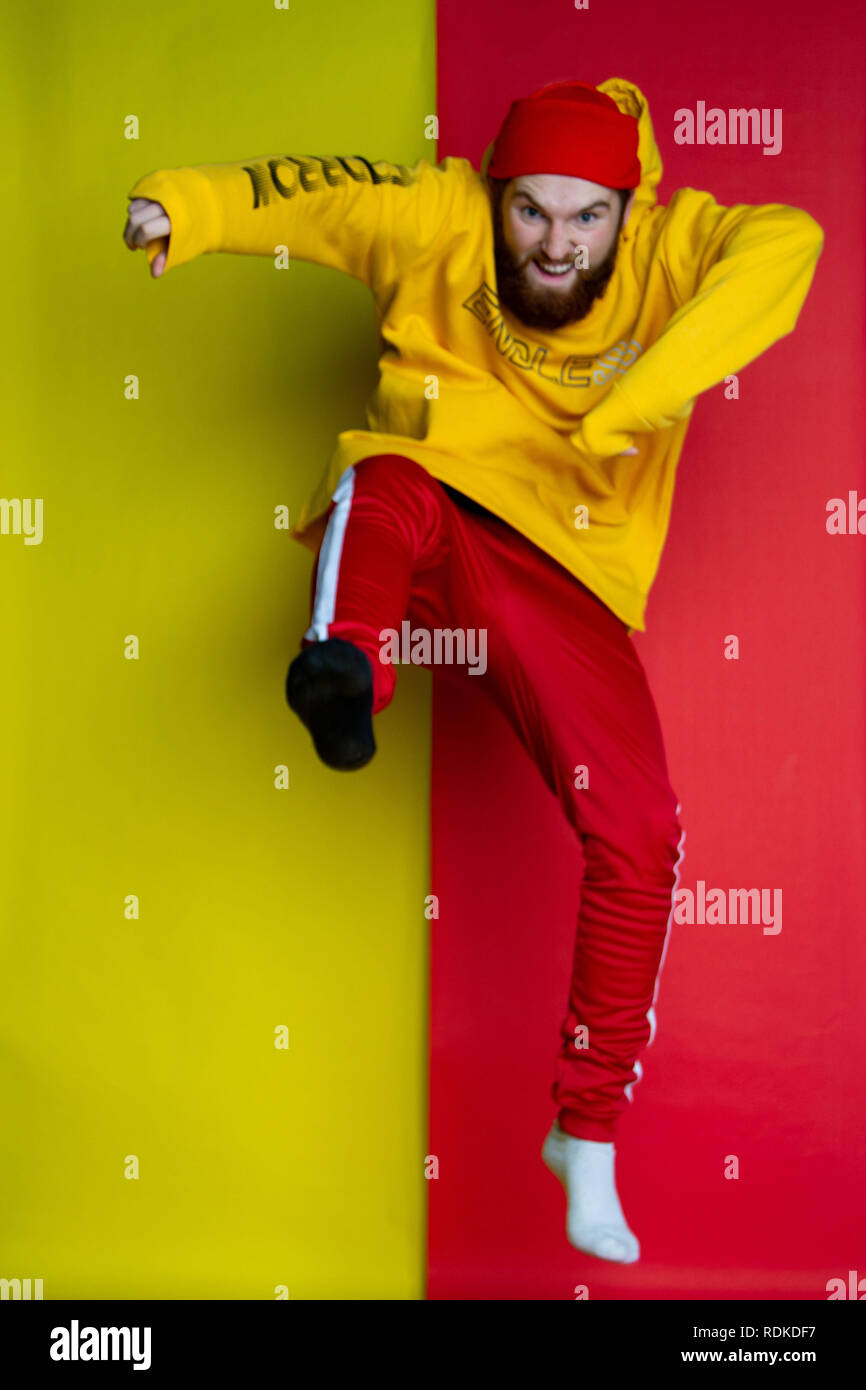 Fashion shot of male posing into the camera wearing clothes that match his backdrop Stock Photo