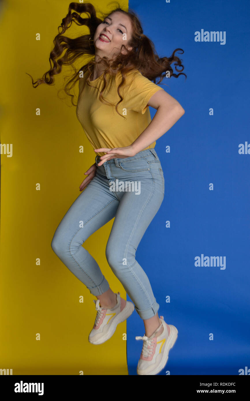Female modelling in Yellow and Blue clothing to match her background Stock Photo