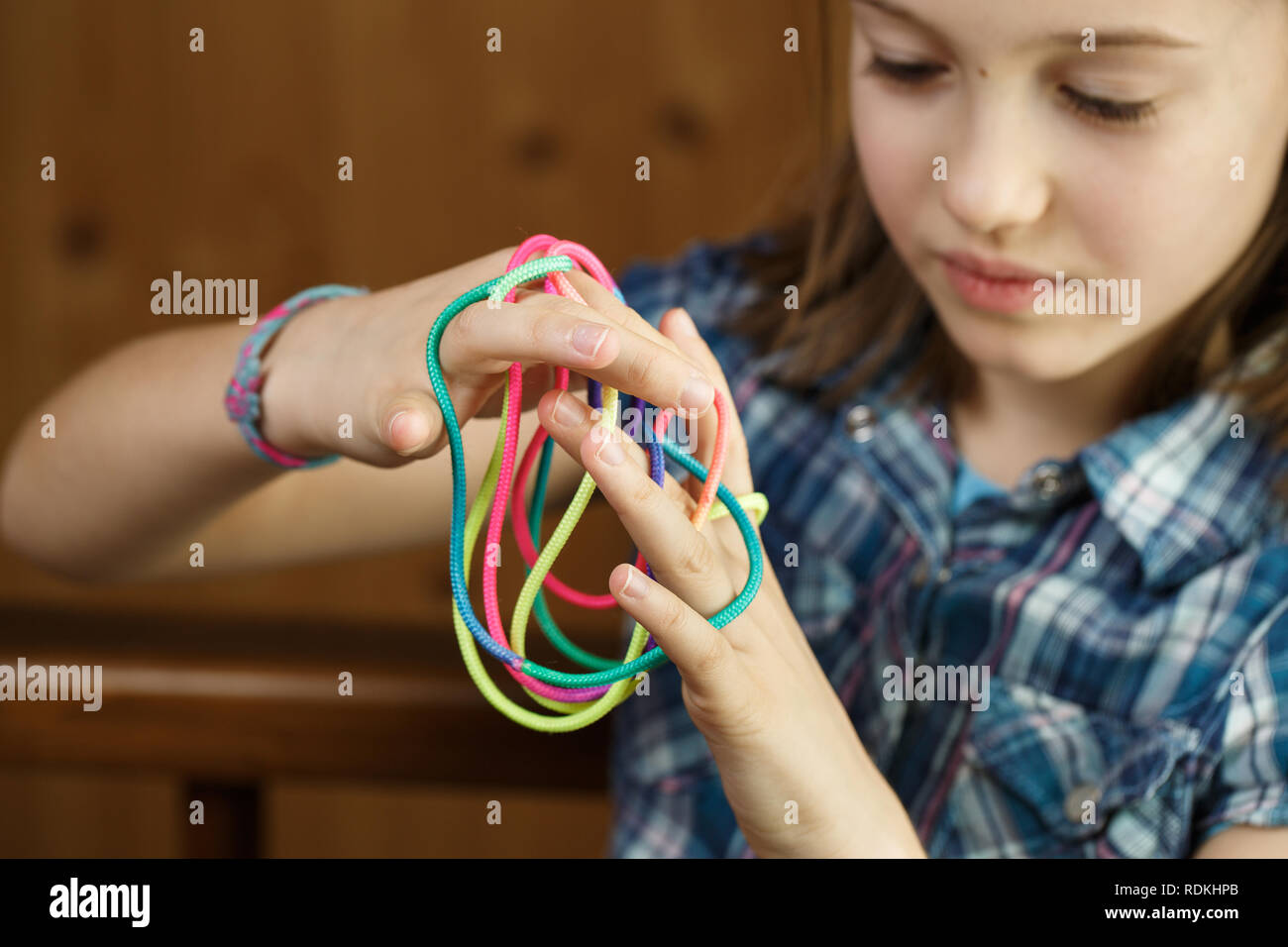 Girl playing classic, old-school string game and didactic toy with her ...