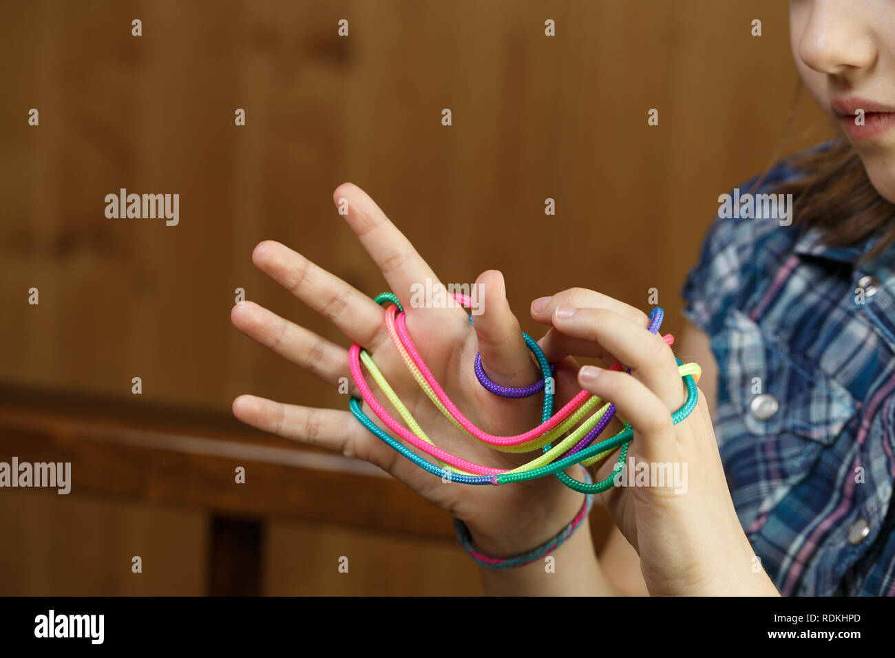 Child playing classic, oldschool string game and didactic toy with her