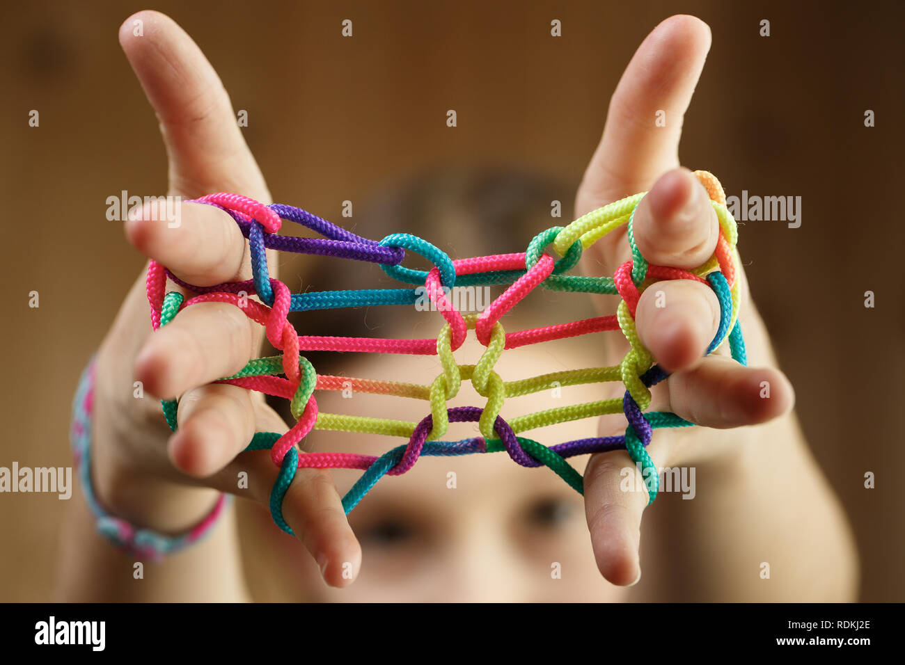 Child playing classic, oldschool string game and didactic toy with her