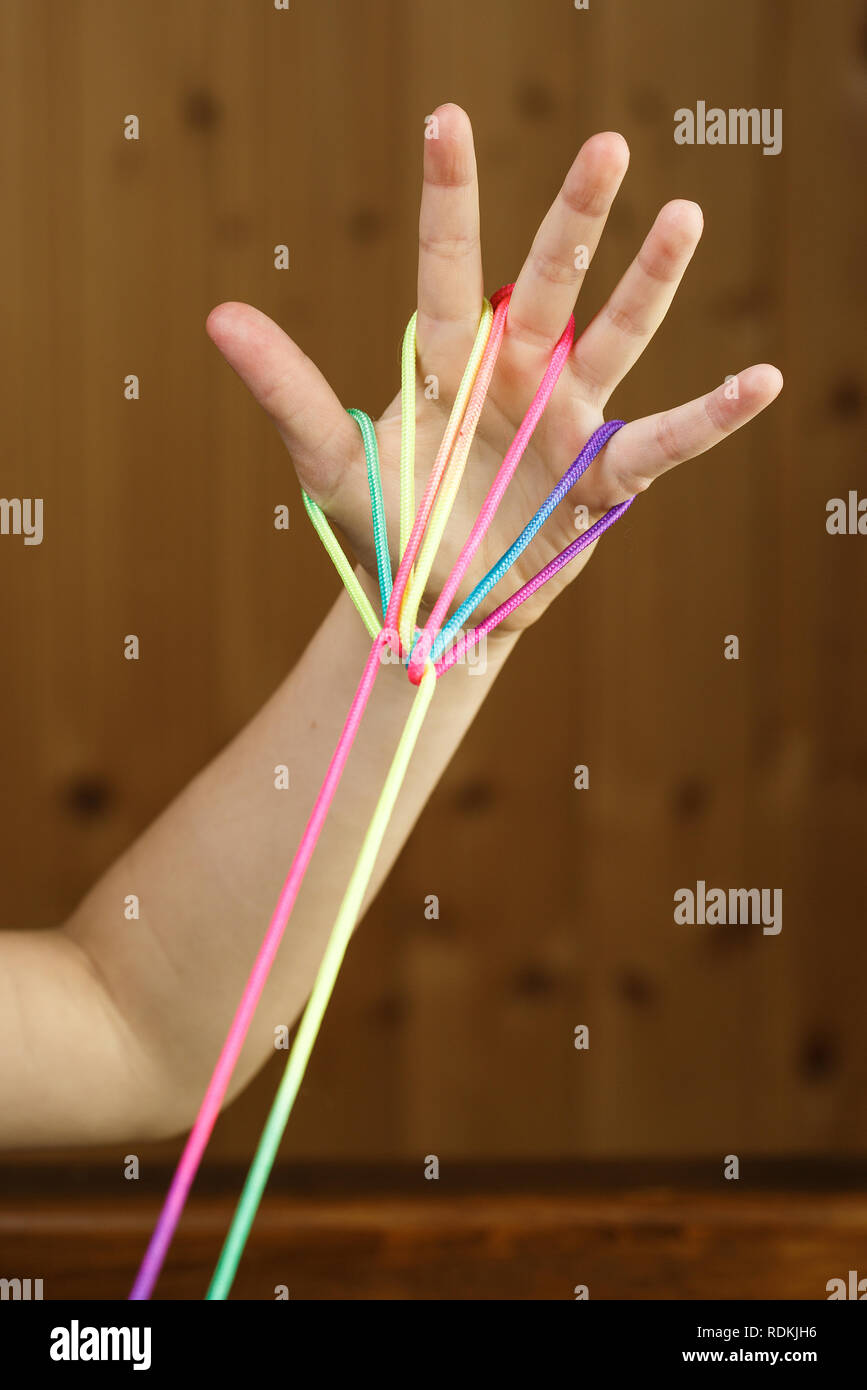 Child playing classic, oldschool string game and didactic toy with her