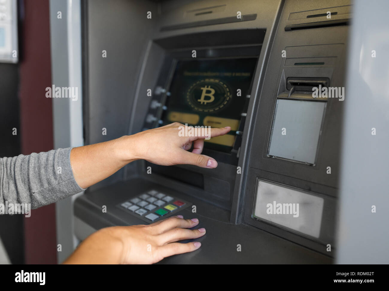 woman at atm machine with bitcoin icon on screen Stock Photo - Alamy