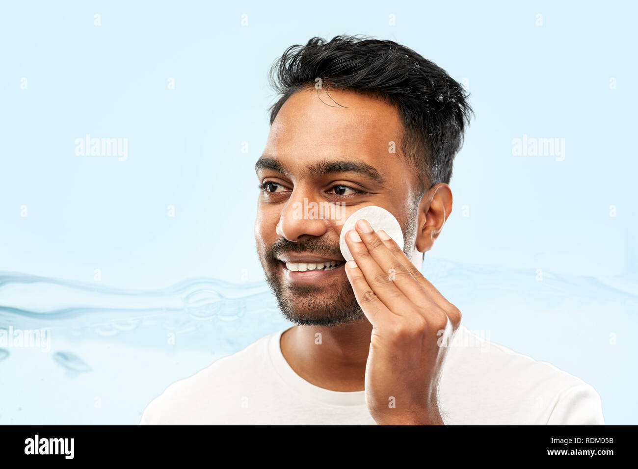 smiling indian man cleaning face with cotton pad Stock Photo Alamy